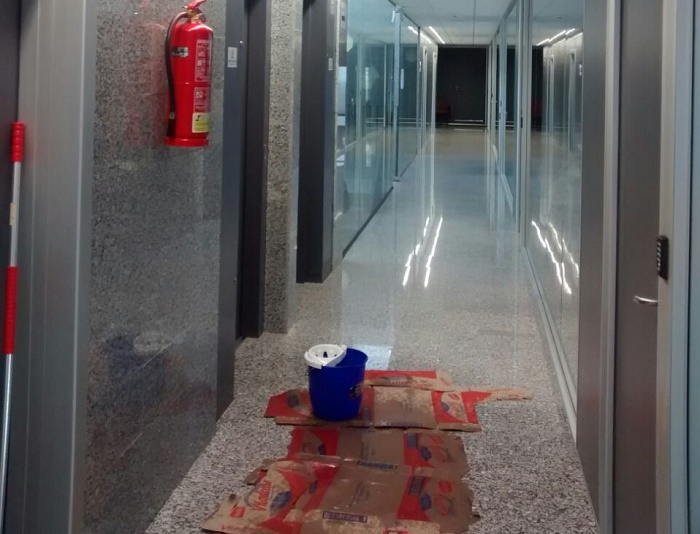 Pasillo de la planta superior del edificio multiusos de Ll&iacute;ria con cubos y cartones, esta ma&ntilde;ana.